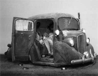 Edward Kienholz; Back Seat Dodge ‘38, 1964. Paint, fiberglass and flock, 1938 Dodge automobile, recorded music and player, chicken wire, beer bottles, artificial grass, and cast plaster figures. 167,6 × 304,8 × 396,2 cm (66 × 120 × 156 inches) - current footprint: 304,8 × 368,3 cm (120 × 145 inches).
