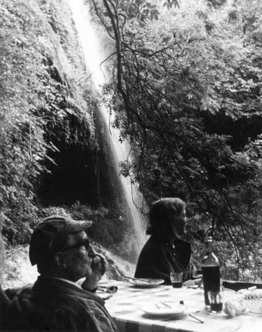 Denise Browne Hare (American, 1924-1997); Marcel Duchamp in engineer’s hat with Teeny in front at La Caula Waterfall, Figueres, Spain, 1965. Gelatin silver print, 25,4 x 20,3 cm.