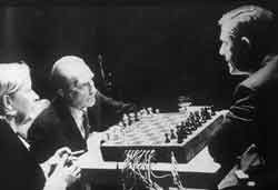 Fragments of Happiness in Art. The Reunion of Electronic Music and Chess. Teeny Duchamp, Marcel Duchamp and John Cage, just before the first game began. Duchamp had not yet removed his king’s knight.
